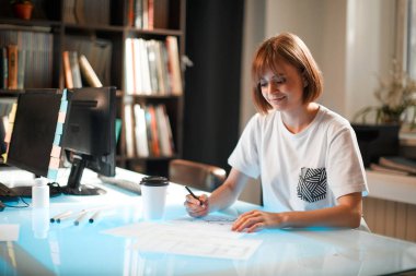 Yaratıcı genç bir kız tasarımcı. Yeni bir proje üzerinde çalışıyor.