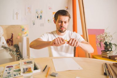 Üzgün adam Illustrator sanatçısı yaratıcılığın sancılarında kalemi kırıyor. İlgisizlik, hayal kırıklığı ve yaratıcı kriz durumu.