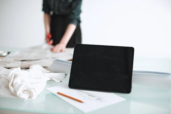 Lugar de trabajo del diseñador de moda, tableta con pantalla vacía en el escritorio en la oficina. Foto para cursos de educación publicitaria o ropa —  Fotos de Stock