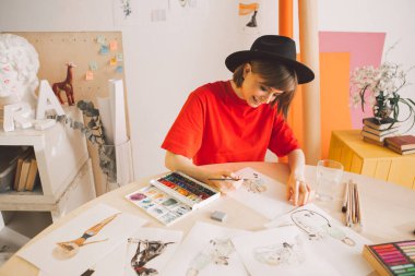 Genç gülümseyen kız çizer atölyede bir film veya karikatür çizer.