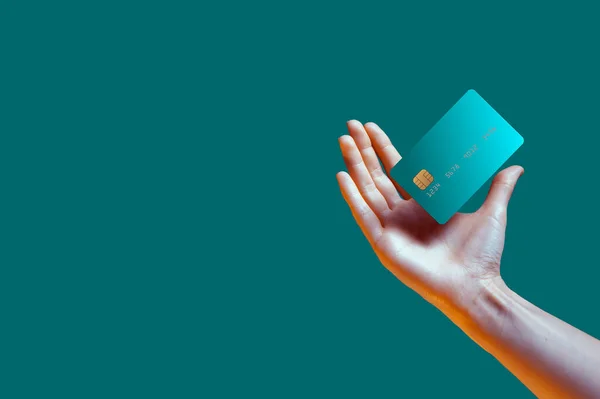 Primer plano mano femenina sostiene plantilla levitante maqueta tarjeta de crédito del banco con servicio en línea aislado en fondo verde — Foto de Stock