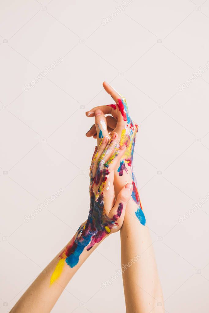 Close up womans artists hands in paints isolated on white background. Colorful photo for art blog or womens blog