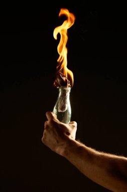 Siyah arka planda yanan bir molotof kokteyli olan erkekler. Protestolar ve savaş hakkındaki konsept fotoğrafçılığı