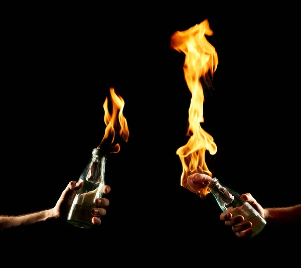 Males hands with a burning Molotov cocktail isolated on black background. Concept photography about protests and war — Stock Photo, Image