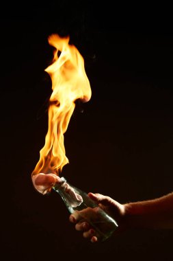 Siyah arka planda yanan bir molotof kokteyli olan erkekler. Protestolar ve savaş hakkındaki konsept fotoğrafçılığı
