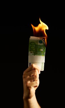 Siyah arka planda izole edilmiş Mans kolunda para yakmak. Protestolar, mali kriz ve iflasla ilgili konsept fotoğraf