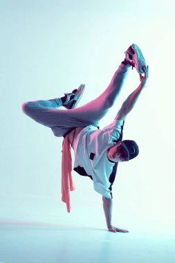 Genç break dansçı bir elinde neon ışıkta hip-hop dansı yapıyor. Dans okulu posteri