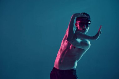 Neon mavi ışıkta tişörtsüz hip-hop dansı yapan havalı genç break dansçı. Dans okulu posteri