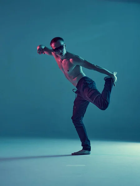 Elegante giovane breakdancer danza hip-hop senza camicia in luce blu fluo. Manifesto della scuola di danza — Foto Stock