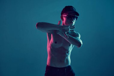 Güneş gözlüklü havalı break dansçı ve neon mavi ışıkta üstsüz hip-hop yapan genç adam. Dans okulu posteri