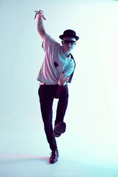 Guy che balla danza contemporanea in studio. Sfondo azzurro al neon. Un ballerino acrobatico. Lezioni di break dance. — Foto Stock