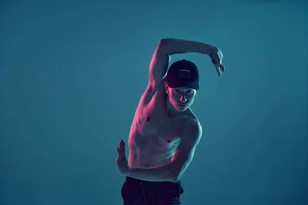 Élégant jeune homme breakdancer danse hip-hop sans chemise en néon lumière bleue. Affiche école de danse — Photo