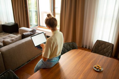 Ev ofisinde boş ekranı olan yaratıcı, sevimli bir blog yazarı. Arkadan bak. Konforlu ev ortamı