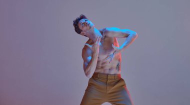 Havalı genç adam neon ışıkta tişörtsüz dans ediyor. Dans okulu posteri