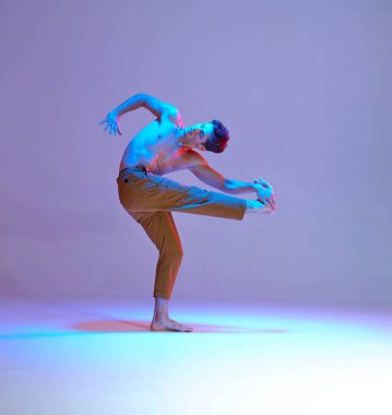 Havalı genç dansçı neon ışıkta tişörtsüz dans ediyor. Renkli dans okulu posteri