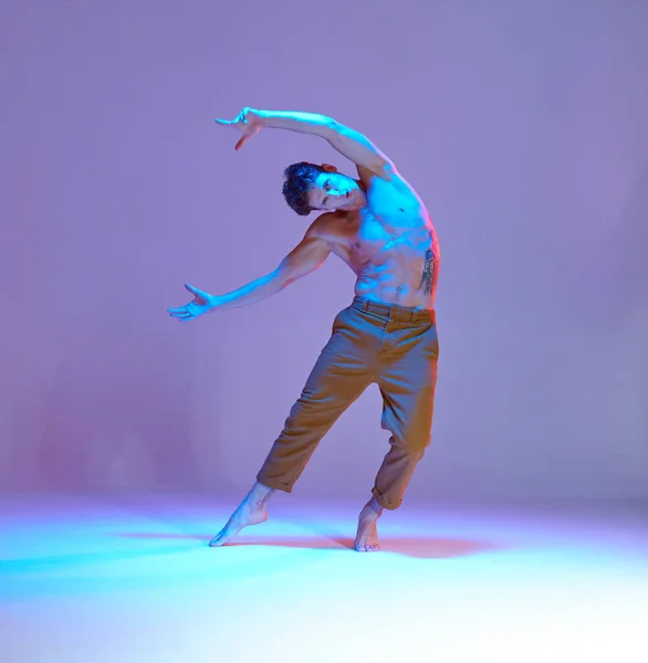 Cool jeune homme dansant sans chemise dans la lumière lilas néon. Affiche d'école de danse. Cours de break dance — Photo