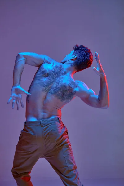 Fresco giovane ballerino senza camicia in luce al neon. Manifesto della scuola di danza. Corpo con tatuaggi. Vista da dietro — Foto Stock