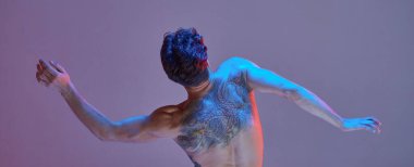Neon lavanta ışığında tişörtsüz havalı genç dansçı. Dans okulu posteri. Dövmeli bir ceset. Arkadan görüntüle
