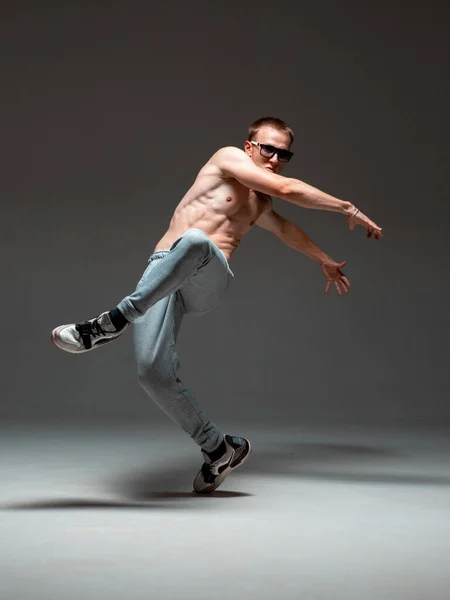 Fajny młody breakdancer w okularach do tańca hip-hop bez koszuli w studio. Plakat szkoły tańca. Lekcje tańca break dance — Zdjęcie stockowe