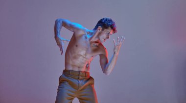 Havalı genç adam profesyonel dansçı, neon ışıkta tişörtsüz dans ediyor. Renkli dans okulu posteri. Break dans dersleri