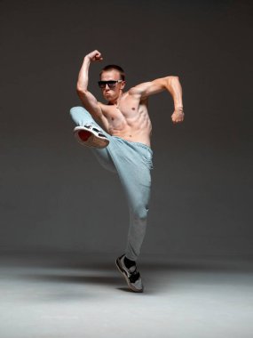 Güneş gözlüklü havalı break dansçı stüdyoda üstsüz hip-hop yapıyor. Dans okulu posteri. Break dans dersleri