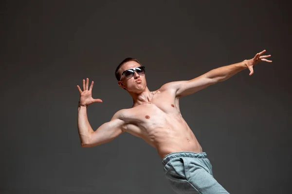 Cool chico breakdancer en gafas de sol bailando hip-hop sin camisa en el estudio. Escuela de baile cartel —  Fotos de Stock