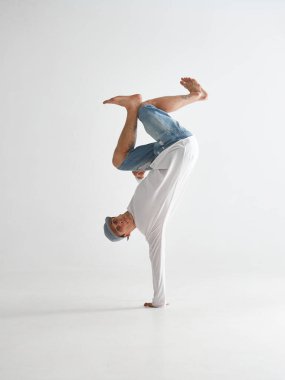 Bir yanda baş aşağı dans eden havalı break dansçı beyaz arka planda tek başına hip-hop yapıyor. Break dans okulu posteri