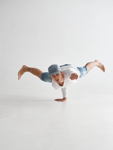 Young breakdancer stands on one arm dancing hip-hop isolated on white background. Break dance school poster