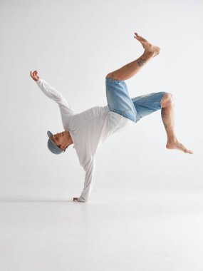 Beyaz arka planda izole bir şekilde break dans yapan havalı break dansçı. Dans okulu posteri. Break dans dersleri