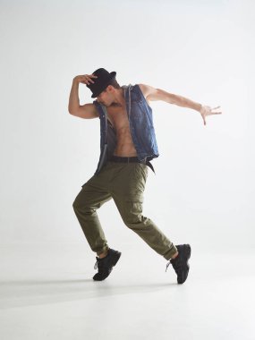 Beyaz stüdyoda dans eden havalı break dansçı genç adam. Dans okulu posteri. Breakdance dersleri