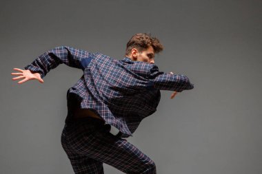 Takım elbiseli şık genç dansçı stüdyoda modern anlamlı danslar yapıyor. Dans okulu posteri. Dans dersleri.