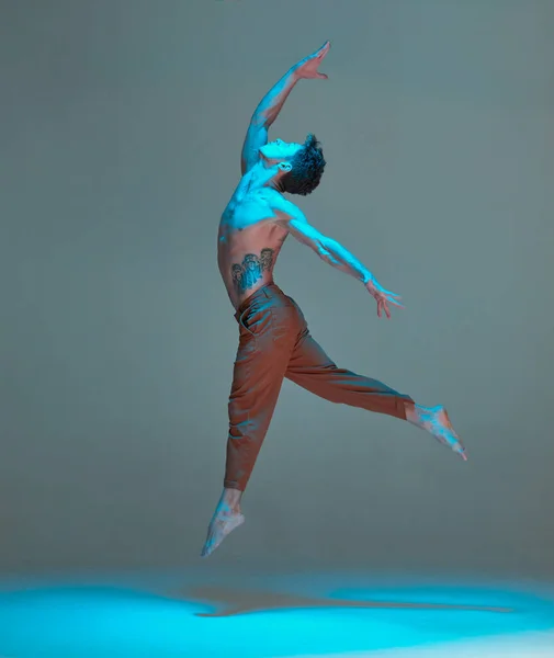 Fajny młodzieniec tańczący i unoszący się w powietrzu w świetle neonów. Plakat szkoły tańca. Lekcje tańca — Zdjęcie stockowe