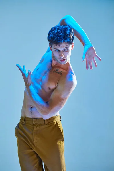 在蓝色霓虹灯下，年轻酷的小伙子跳着没有衬衫的有表现力的舞蹈。多彩的舞蹈学校海报 — 图库照片