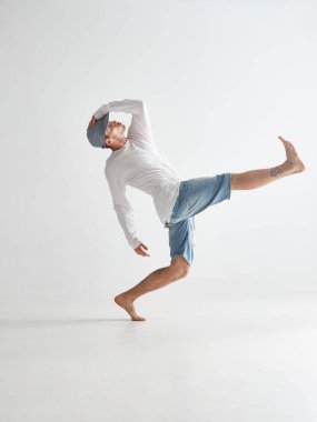 Beyaz arka planda izole edilmiş havalı break dans yapan hip-hop dansçısı. Dans okulu posteri. Break dans dersleri