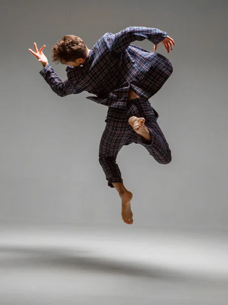 Stylowy tancerz lewitujący na szarym tle. Plakat szkoły tańca. Widok z tyłu. Fotografia aplikacji lub reklamy — Zdjęcie stockowe
