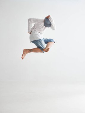 Beyaz arka planda izole edilmiş havalı dansçı adam havada süzülüyor. Dans okulu posteri. Uygulama veya reklam için fotoğrafçılık