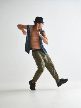 Beyaz arka planda izole edilmiş, şapka giyen, hip-hop yapan havalı bir break dansçı.