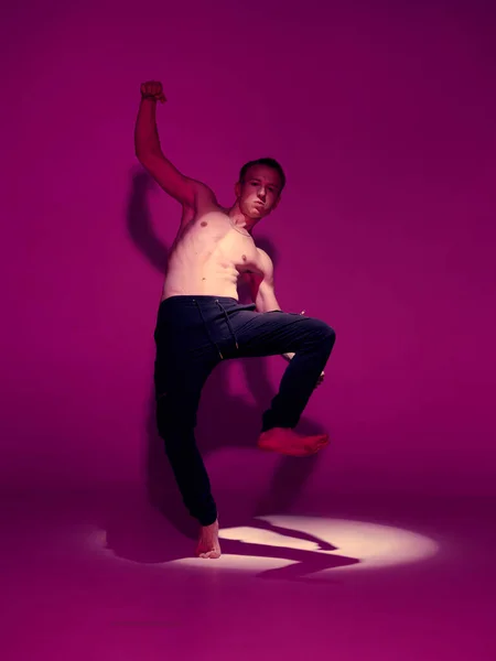 Jeune danseur cool avec torse nu dansant en studio dans la lumière rose. Affiche école de danse — Photo