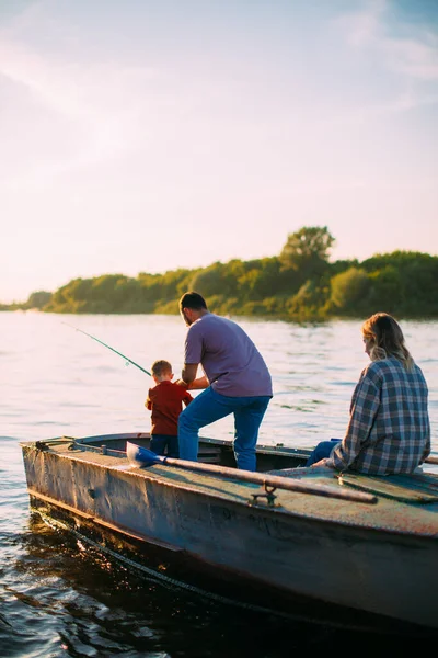 Feliz pesca familiar en barco en el río en verano. Vista trasera. Fotografía para anuncio o blog sobre familia y viajes —  Fotos de Stock