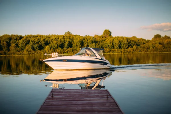 Sükunet göl ya da nehir kıyısındaki rıhtımın yakınındaki eğlence teknesi denize açılır. Yaz dönemi manzara fotoğrafçılığı