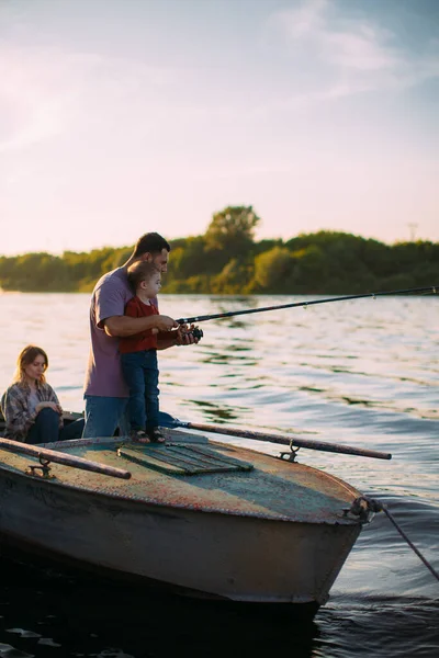 夏天，幼小的家庭在河里钓鱼。父亲教儿子钓鱼。有关家庭旅行的博客照片 — 图库照片