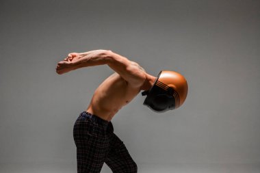 Stüdyoda kasklı yarışçı gri arka planda arka planda kemer takıyor. Kart Yarış Okulu posteri