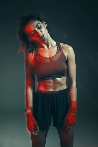 Chica luchadora está de pie en vendas de boxeo en el estudio sobre fondo gris. Cartel de artes marciales mixtas para mujer — Foto de Stock