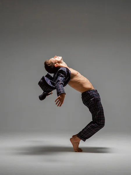 Bel homme flexible dansant danse expressive en costume avec torse nu isolé sur fond gris — Photo