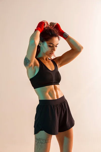 Retrato de chica bonita en ropa deportiva con estilo de pie en el estudio aislado sobre fondo beige. Mujeres estilo de vida activo — Foto de Stock