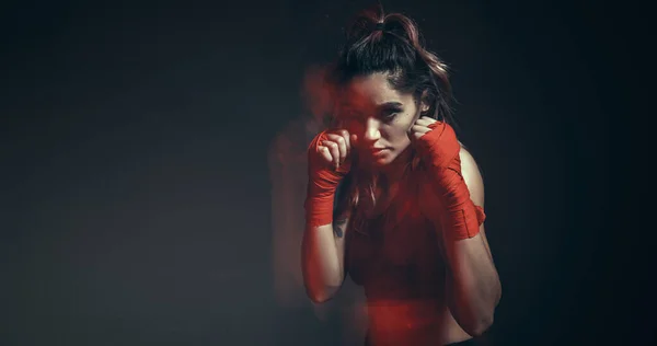 Lutadora muito feminina em ataduras de boxe treina em estúdio em luz de néon. Cartaz de artes marciais mistas. Longa exposição tiro — Fotografia de Stock