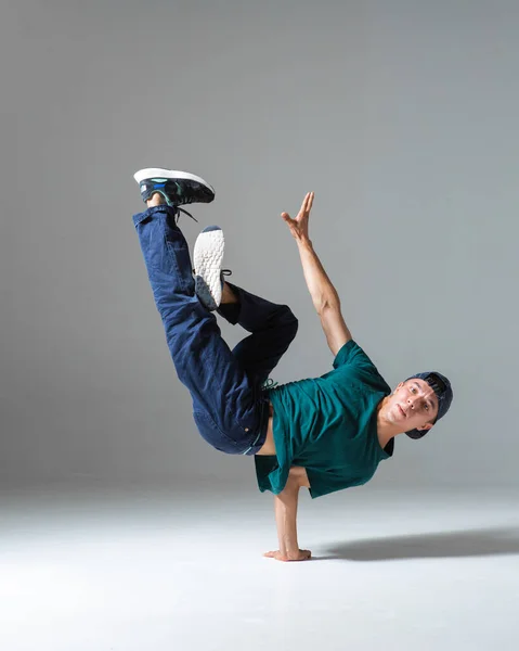 Fajny b-boy taniec breakdance na podłodze w studio izolowane na szarym tle. Plakat szkoły breakdance — Zdjęcie stockowe