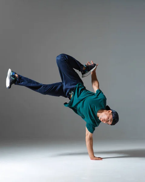 Fajny b-boy taniec breakdance na podłodze w studio izolowane na szarym tle. Plakat szkoły breakdance — Zdjęcie stockowe