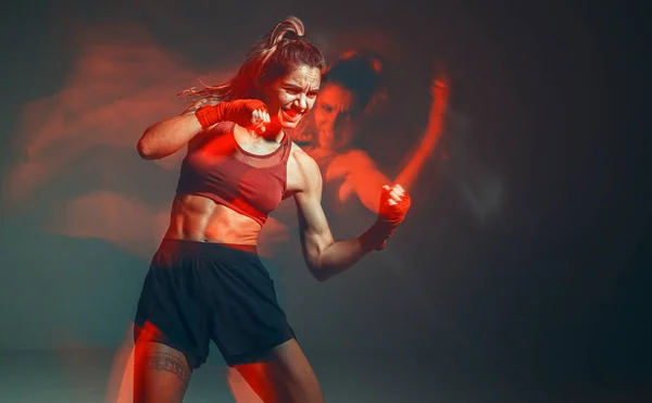 Boks bandajlı havalı kadın boksör stüdyoda kırmızı ışıkta tren kullanıyor. Karışık dövüş sanatları posteri. Uzun pozlu çekim