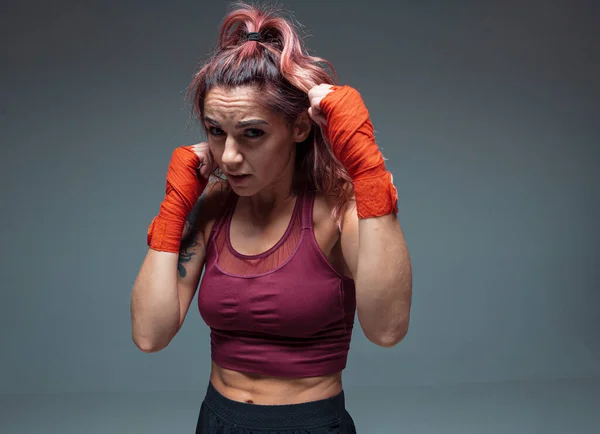 Retrato de lutadora feminina em bandagens de boxe de pé em estúdio isolado em fundo cinza — Fotografia de Stock